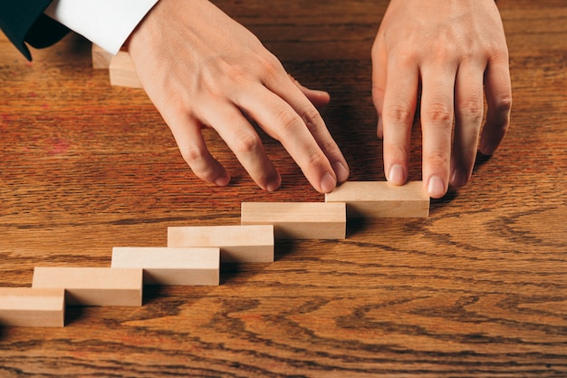 Hombre y cubos de madera en la mesa. Concepto de gestión