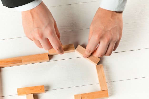 Hombre y cubos de madera en la mesa. Concepto de gestión