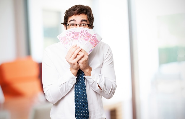 Hombre cubriendo su cara con billetes