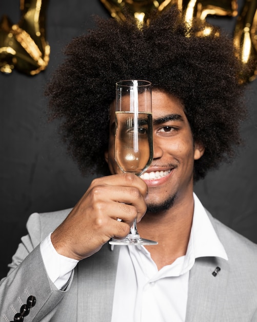 Hombre cubriéndose la cara con una copa de champán