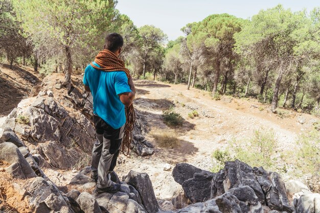 Hombre con cuerda en bosque