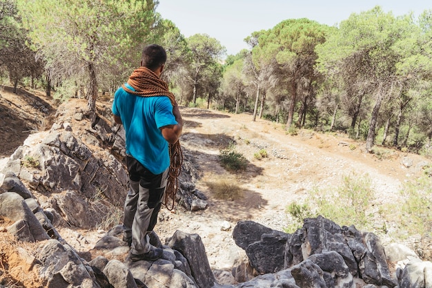 Hombre con cuerda en bosque