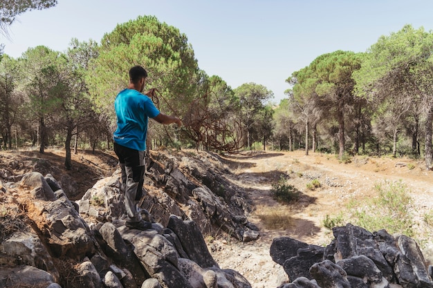 Hombre con cuerda en bosque