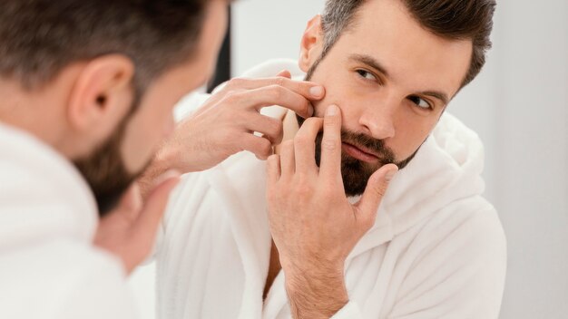 Hombre cuidando bien su rostro en casa