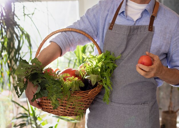 Hombre cultivando verduras en su jardín interior