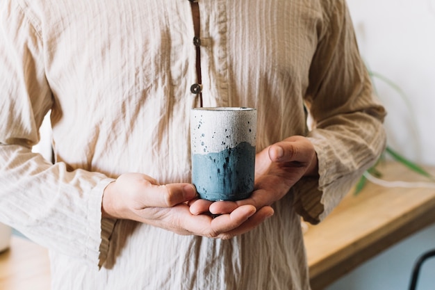 Hombre de cultivo sosteniendo la taza