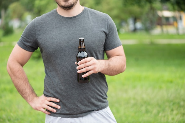 Hombre de cultivos con cerveza en el parque