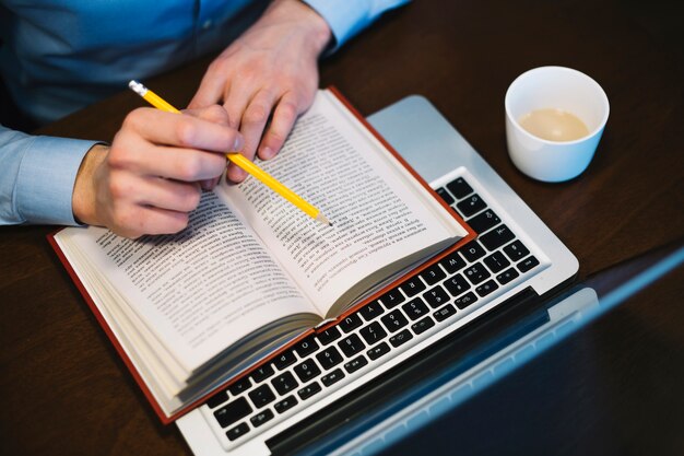 Hombre de cultivos estudiando cerca de la computadora portátil