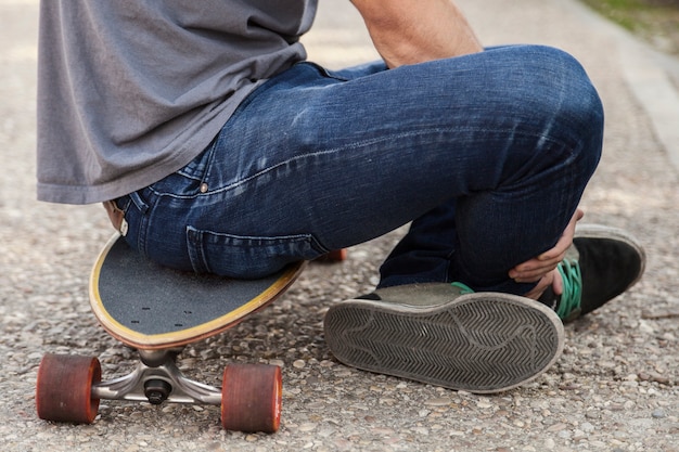 Hombre de cultivos sentado en longboard