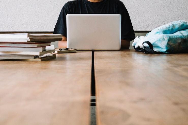 Foto gratuito hombre de cultivos usando la computadora portátil en el aula
