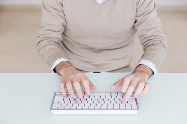 Hombre de cultivos usando el teclado de la computadora