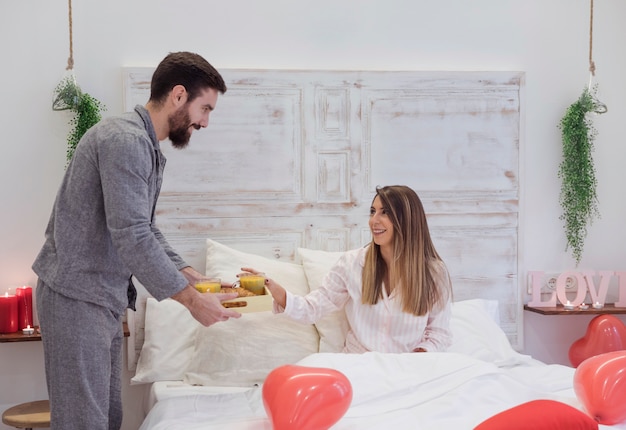 Foto gratuita hombre dando desayuno romántico a mujer.