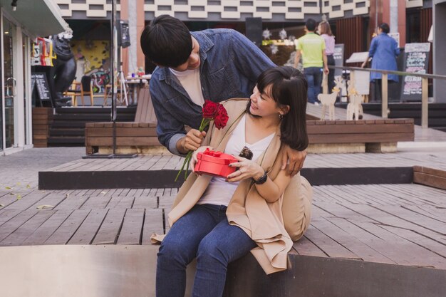 Hombre dando flores a una chica en la calle