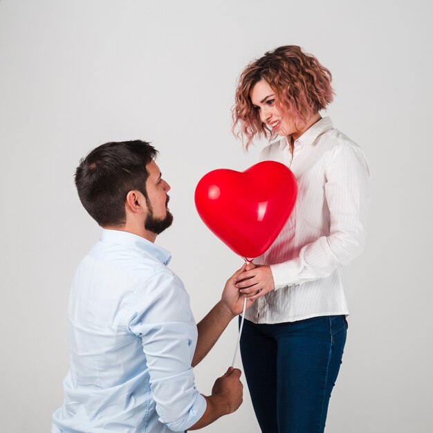 Hombre dando globo mujer para San Valentín