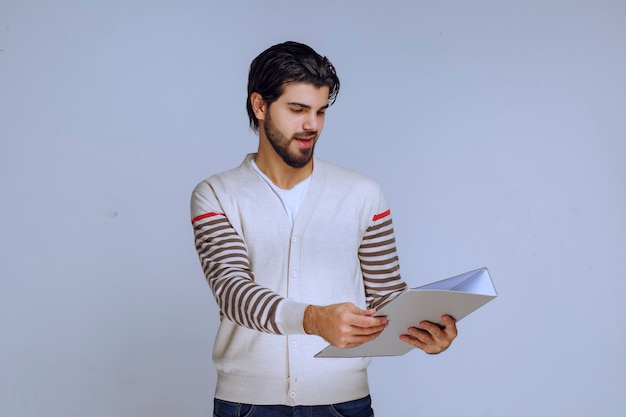 Hombre dando o recibiendo la carpeta de informes.