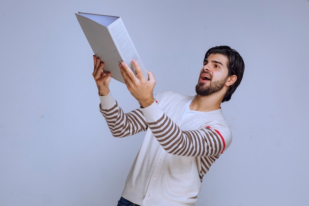 Hombre dando o recibiendo la carpeta de informes.