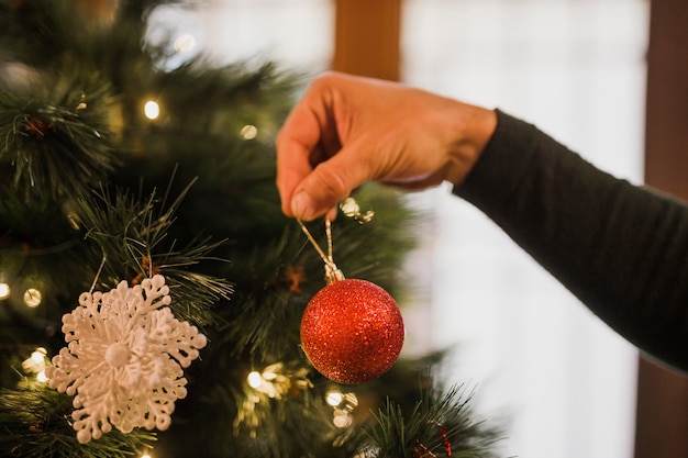 Foto gratuita hombre decorando el árbol de navidad