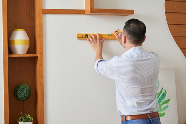 Foto gratuita hombre decorando la pared con foto