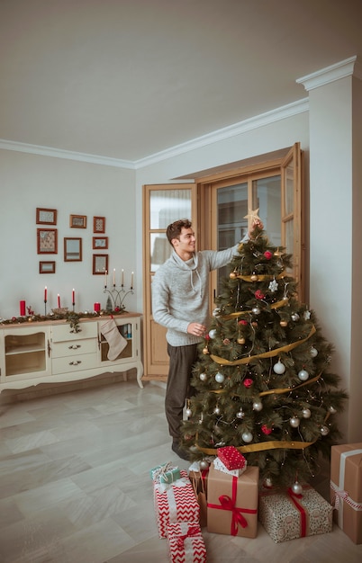 Hombre, decorar, árbol de navidad, en, sala