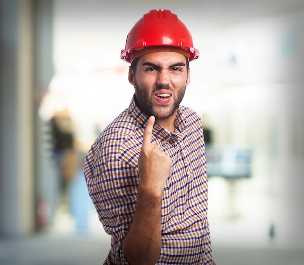 Hombre con un dedo levantado celebrando y un casco rojo