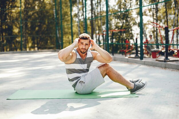 Hombre de deportes en un parque de verano por la mañana