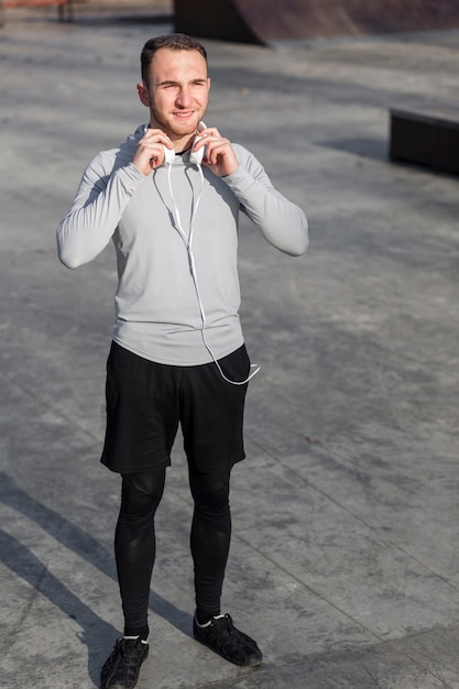 Hombre deportivo con auriculares y mirando a otro lado