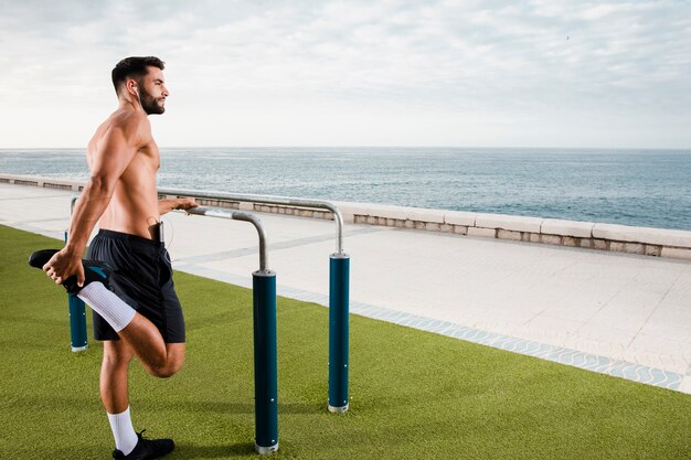 Hombre deportivo calentando antes del entrenamiento