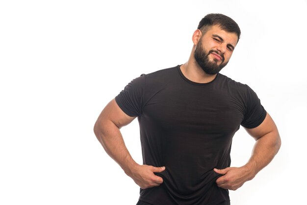 Hombre deportivo con camisa negra tiene sobrepeso.