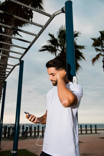 Hombre deportivo escuchando música al aire libre