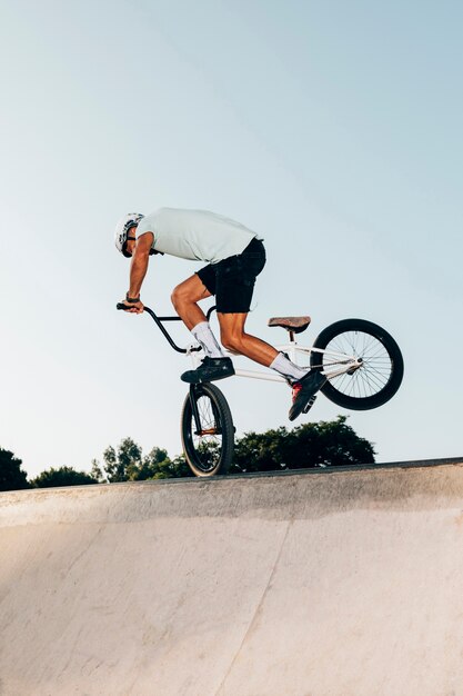 Hombre deportivo saltando alto con bicicleta