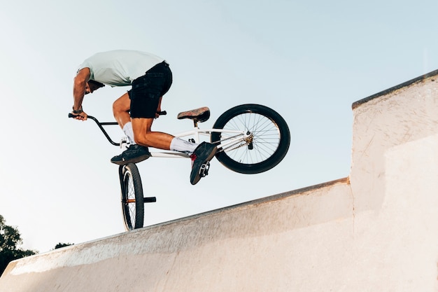 Hombre deportivo salto extremo con bicicleta