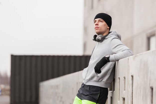 Hombre deportivo sujetándose en un muro 