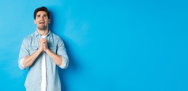 Foto gratuita hombre desesperado rogando y llorando por ayuda suplicando a dios mirando hacia arriba y tomados de la mano en el puesto de oración