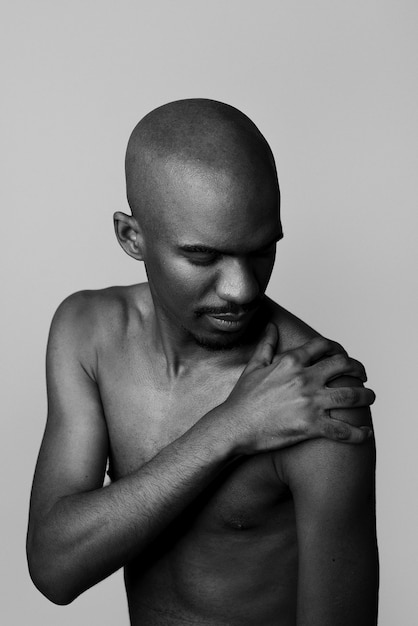 Hombre desnudo posando en el estudio tiro medio en blanco y negro