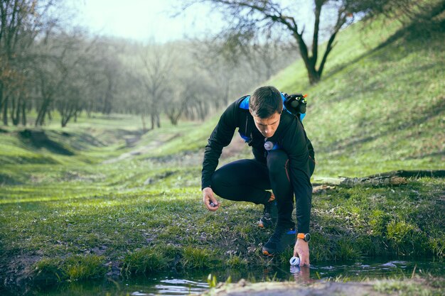 Hombre después de correr en un parque o bosque contra árboles