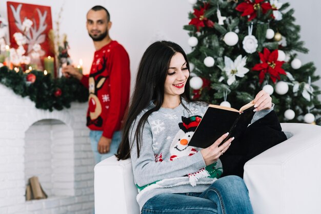 Hombre detras de mujer con libro