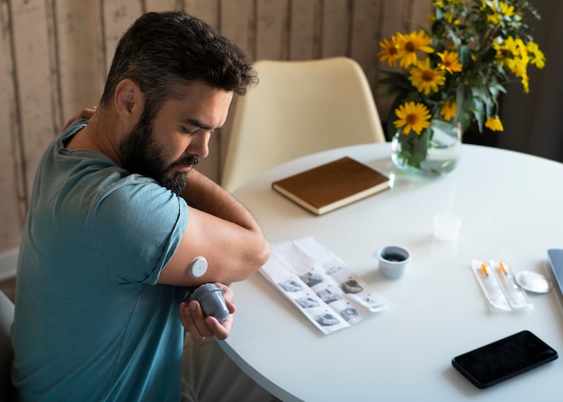 Foto gratuita hombre diabético comprobando el sensor de parche de glucosa