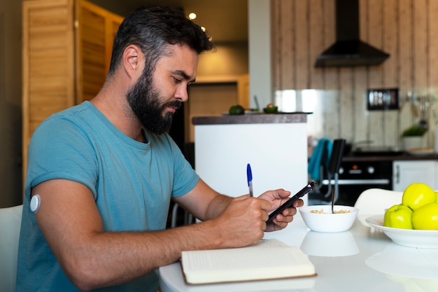 Foto gratuita hombre diabético comprobando el sensor de parche de glucosa