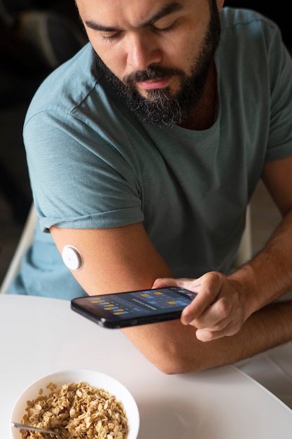 Foto gratuita hombre diabético comprobando el sensor de parche de glucosa