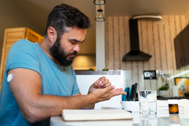 Foto gratuita hombre diabético comprobando el sensor de parche de glucosa