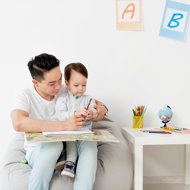 Foto gratuita hombre dibujando con un niño mientras está en casa