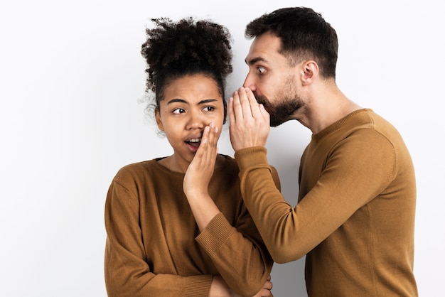 Hombre diciéndole a la mujer un secreto