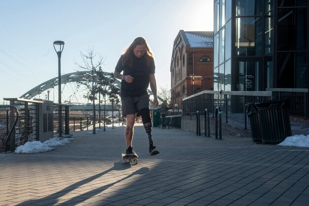 Hombre con discapacidad en la pierna patinando en la ciudad