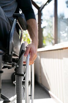 Hombre discapacitado de ángulo bajo en silla de ruedas