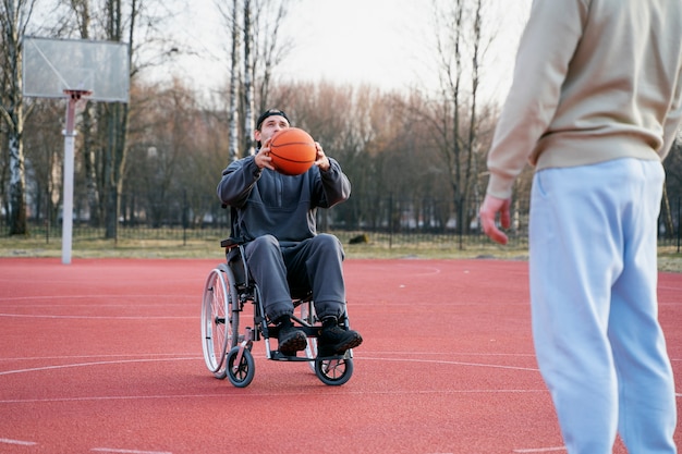 Hombre discapacitado con baloncesto al aire libre