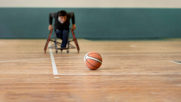 Hombre discapacitado de disparo completo que va después del baloncesto