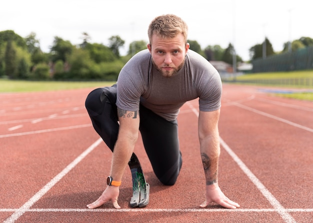 Hombre discapacitado en pista de atletismo full shot