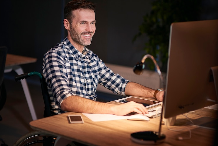 Foto gratuito hombre discapacitado que trabaja con tecnología en la oficina en casa