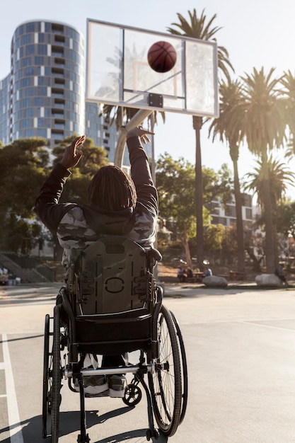 Hombre discapacitado en silla de ruedas jugando baloncesto