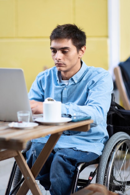 Foto gratuita hombre discapacitado de tiro medio trabajando en equipo portátil